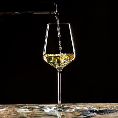Lehmann Hera 39 waarin witte wijn uit een fles wordt geschonken, op een marmeren blad voor een zwarte achtergrond