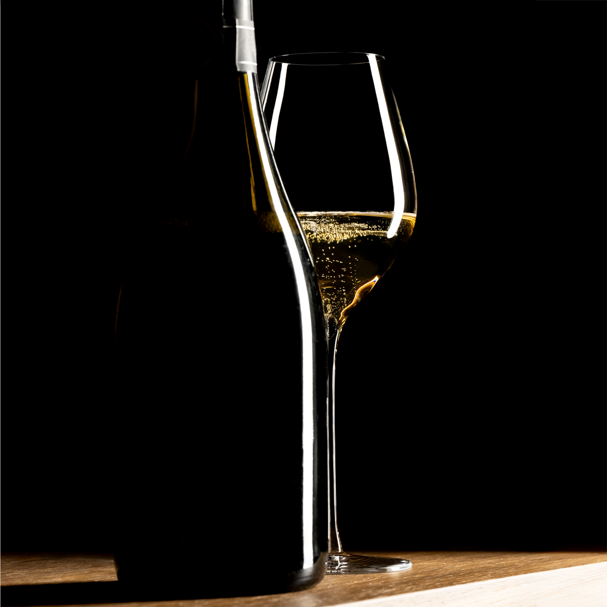 Lehmann N°4 40 Ultralight met champagne naast het silhouet van een donkere fles, op een houten blad tegen een zwarte achtergrond